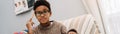 Black puzzled boy doing homework while sitting on sofa Royalty Free Stock Photo