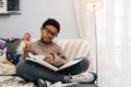Black puzzled boy doing homework while sitting on sofa Royalty Free Stock Photo