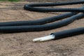 Black PVC electric pipes with wires on the ground. Construction site, power line with cable wires Royalty Free Stock Photo