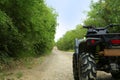 Black quad bike on pathway near trees outdoors, space for text