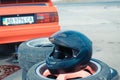 Black racing helmet resting on a pile of used tires at Vinnytsia Drift Competition 09.07.2017, editorial photo
