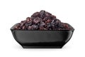 Black raisin in black bowl isolated on white. Front view Royalty Free Stock Photo