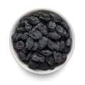 Black raisin in white bowl isolated on white. Top view Royalty Free Stock Photo