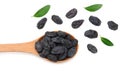 black raisins in wooden spoon with green leaves isolated on white background. top view Royalty Free Stock Photo