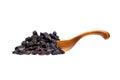 Black raisins in the wooden spoon, isolated on white background. Royalty Free Stock Photo