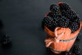 Black raspberries in a wooden basket on background. Frame. Copy space. Top view. Royalty Free Stock Photo