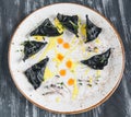 Black ravioli with seafood. On a plate top view. On wooden gray background