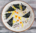 Black ravioli with seafood. On a plate top view. On wooden gray background.