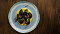Black ravioli with seafood on a wooden background