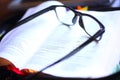 Black Reading Eye glasses on open book bible with shadow