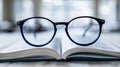 Black Reading Glasses Resting on an Open Book - Focus and Knowledge Concept Royalty Free Stock Photo