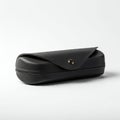 A black, rectangular eyeglass case with a textured surface and a front flap secured by a