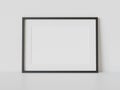 Black frame leaning on white floor in interior mockup. Template of a picture framed on a wall 3D rendering Royalty Free Stock Photo