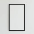 Black rectangular frame with a minimalistic design set against a plain white wall. The Royalty Free Stock Photo