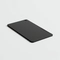A black rectangular object with rounded corners lies on a plain white surface. It has a Royalty Free Stock Photo