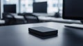 A black rectangular object sits on a black desk. Royalty Free Stock Photo