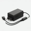 Black rectangular power adapter with USB cables on a white background. Features two Royalty Free Stock Photo