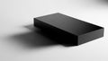 Black rectangular prism lies on a white surface, casting a shadow to the left Royalty Free Stock Photo