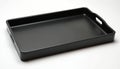 Black rectangular serving tray with cut-out handles, isolated on clean white background. Versatile tableware object perfect for Royalty Free Stock Photo