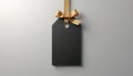 Black rectangular tag hangs with gold ribbon bow. Blank label has rounded corners and thin border. Empty space for text or logo. Royalty Free Stock Photo