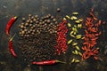 Black and red bell pepper, chili pepper, cardamom and goji berries on a dark background. A variety of spices. View from above