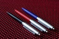 Black, red and blue pens on an ultramodern red and black background made using nanotechnology. The concept of teaching in a modern