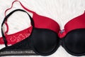 Black and red bra on white fur. Flat lay. Fashion concept Royalty Free Stock Photo