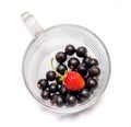 Black and red currant in a transparent glass cup on a white isolated background_ Royalty Free Stock Photo