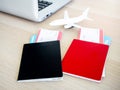 Black and red, differnt color of two passports with blank cover with two flight tickets.