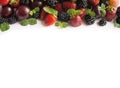 Black and red food at border of image with copy space for text. Ripe blackberries, strawberries and plums on white background. Top Royalty Free Stock Photo