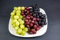 Black, red, green seedless grapes in a deep white bowl Royalty Free Stock Photo