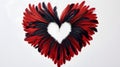 Black and red heart made of feathers