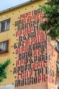 Black and red lettering on the wall of a building in Tirana