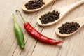 Black and red pepper in wooden spoon Royalty Free Stock Photo