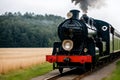 A black and red train traveling down train tracks, steam train.