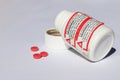 Black, red and white Medicine May Cause Drowsiness warning label on pill bottle and red pills Royalty Free Stock Photo