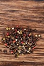 Top view on black, red and white peppercorns on wooden background, shallow depth of field.