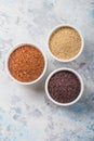 Black, red and white quinoa grains in a plate on white background. Gluten free Healthy food. Chenopodium quinoa closeup Royalty Free Stock Photo