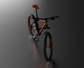 Black reflecting floor with a Front View of an Orange and Black Mountain Bike Royalty Free Stock Photo