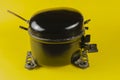 Black Motor-Compressor of the refrigerator on a yellow background Royalty Free Stock Photo