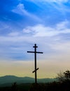 Black religion symbol silhouette Jesus Christ wooden cross on a background with colorful mountain sunset, Easter concept Royalty Free Stock Photo