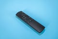 Black remote control on blue background