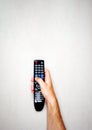 Black remote control from the TV in a male hand on a light gray background Royalty Free Stock Photo