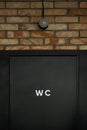 Black restroom door with a WC sign on it. Modern public toilet entrance. .Loft style interior design