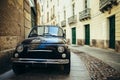 Black retro car parked on narrow italy street in Sardinia island Royalty Free Stock Photo