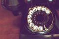 Black retro phone on blurred wood deck. Royalty Free Stock Photo