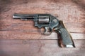 Black revolver gun with bullets isolated on wooden background Royalty Free Stock Photo