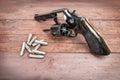 Black revolver gun with bullets isolated on wooden background Royalty Free Stock Photo