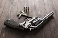 Black revolver gun with bullets isolated on wooden background Royalty Free Stock Photo