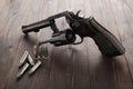 Black revolver gun with bullets isolated on wooden background Royalty Free Stock Photo